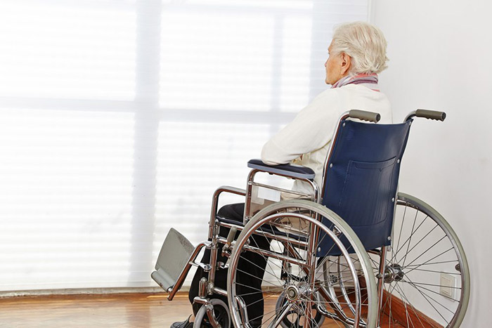 Senior man sitting lonely on a wheel chair