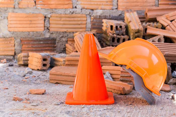 construction helmet safety and cone in construction site with bricks